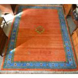 A large Turkish orange ground wool rug with central medallion and four small figures within a blue