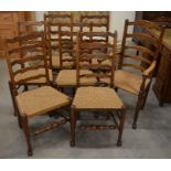 A set of seven oak wavy ladderback dining chairs with woven rush seats comprising 6 standard and 1