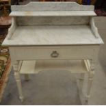 A cream painted wash stand with galleried marble top, frieze drawer and open undertier raised on