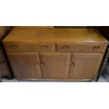 An Ercol elm sideboard with three drawers