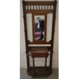 A 1930s mahogany hall stand with mirror, coat hooks and hinged glove box and c/w inset drip pans