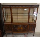 A carved mahogany part glazed breakfront display cabinet on turned supports