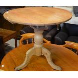 An antique circular pine tilt-top table on birdcage mount, turned column and triform supports