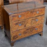 A crossbanded walnut three drawer chest with brass handles, raised on bracket feet