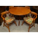 A stained elm circular dining table on turned column and triform supports to/w four matching spindle