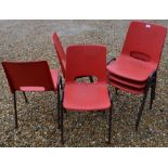 Six red plastic stacking chairs (6)