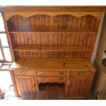 A waxed pine kitchen dresser, the plate rack with two shelves on a base with four drawers arranged