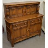 An Ercol dark elm low dresser with panelled cupboards and two drawers