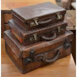 Two vintage leather suitcases, another suitcase and an oval painted metal hatbox with a collection