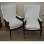 A pair of mahogany framed wing back arm chairs, cream upholstery