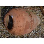 A small weathered terracotta oil pot