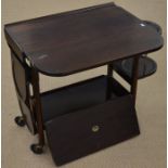 A 1920s tea trolley with drop leaf top and folding cake trays
