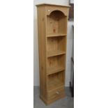 A tall and narrow pine open bookcase with three shelves and single drawer raised on plinth base