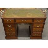A small Edwardian mahogany twin pedestal desk with gilt tooled green leather top and nine drawers