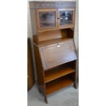 An Edwardian mahogany shallow bureau with blind fret-cut decoration around two glazed doors over