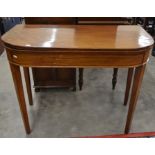 A George III mahogany folding card table raised on tapering supports