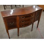 An Edwardian crossbanded mahogany serpentine front sideboard with three central 'drawers' flanking