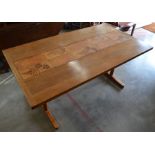 A 1970's teak dining table, the cleated rectangular top inset with central tiles, raised on a pair