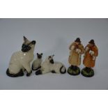 A trio of Royal Doulton Siamese cats and two figures