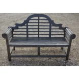 A weathered Lutyens design teak garden bench