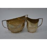 A heavy quality silver half-reeded milk and sugar pair of elliptical form