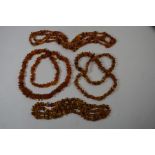 Four various rows of tumbled amber bead necklaces