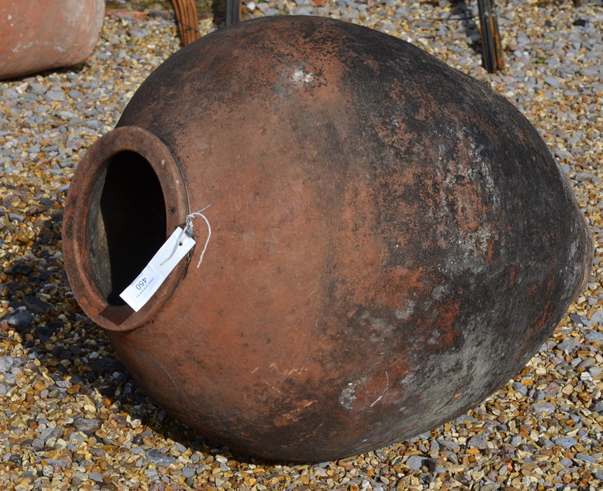 A weathered terracotta oil jar