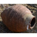 An antique weathered terracotta olive jar