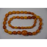 A row of graduated oval amber beads