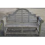 A weathered Lutyens design teak garden bench