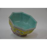 A Chinese octagonal famille rose bowl, alternating floral and phoenix panels on yellow ground