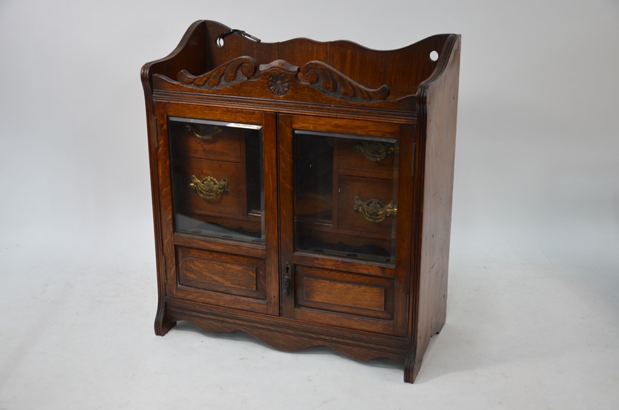 A late Victorian oak smoker's cabinet