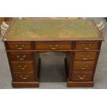 A small Edwardian mahogany twin pedestal desk with gilt tooled green leather top and nine drawers,