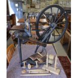 A turned wooden spinning wheel c/w a box of accessories including shuttles, carding comb etc