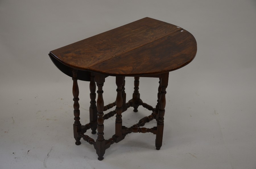 A small Oak drop leaf side table on turned gate-leg action supports