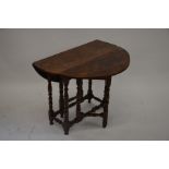 A small Oak drop leaf side table on turned gate-leg action supports