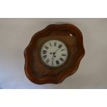 An oak framed wall clock with shaped case, white dial with Roman numerals, twin train movement, 61