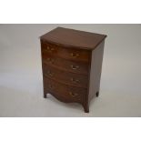 A small mahogany bowfront chest of four drawers raised on shaped feet, 59 cm wide x 43 cm deep x