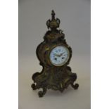 A 19th century French ornate cast brass mantle clock with enamelled dial and twin train movement, 46