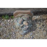 Weathered cast terracotta cherub wall bracket