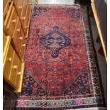 A Hamandan rug with navy medallion on red ground and ivory border,  210 x 125cm