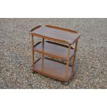 Ercol elm three tier trolley with turned beech supports and metal castors