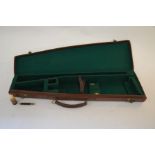 A vintage leather gun case with fitted green baize line interior