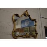 A modern gilt framed shaped mirror in the rococo manner