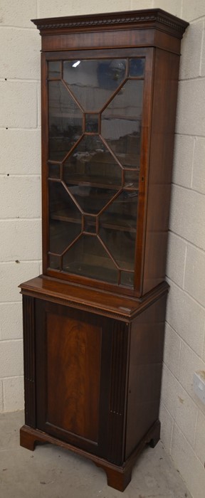 An Edwardian mahogany bookcase cabinet with astragal glazed door enclosing three shelves over a