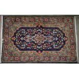 A Kerman dark blue ground rug with floral decorated central medallion, 145 x 95 cm