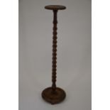 An early 20th century oak jardiniere stand with barley-twist column and circular platform base on