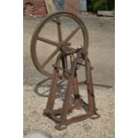 A vintage cast iron hand crank-operated derrick on frame