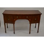 A 19th century mahogany bow front sideboard with three drawers, raised on square tapering supports