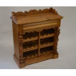 A Continental carved and waxed pine wine rack with cushion moulded drawer and three open shelves, 84